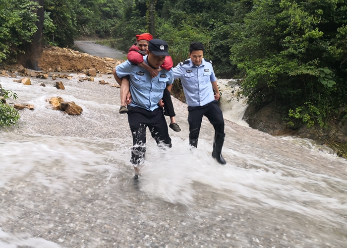 韶关公安民警背着老人蹚过洪水浸淹路段。（警方供图）.jpg