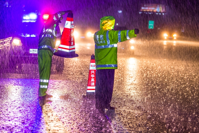 梅州公安交警冒雨在济广高速梅州五华樟树塘立交疏导车流。（摄影：何志林）.jpg