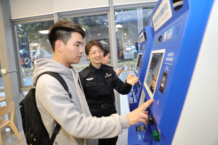 深圳市八卦岭派出所民警指引群众使用自助办证机快速办理业务.jpg